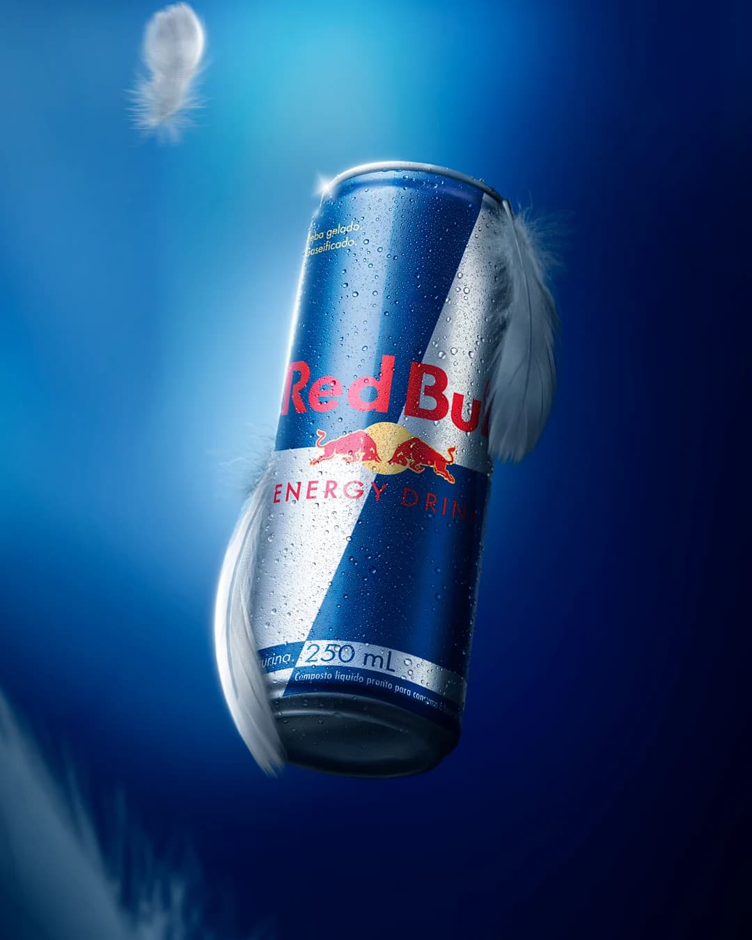 Lata de Red Bull em uma composição publicitária azul com gotas de água